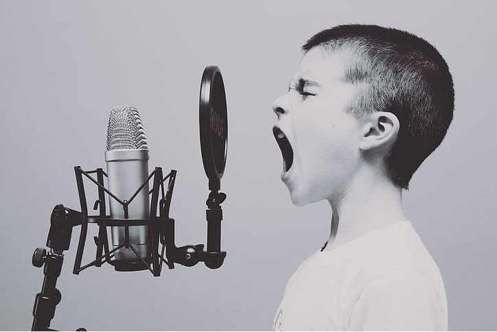 a boy singing into a studio microphone