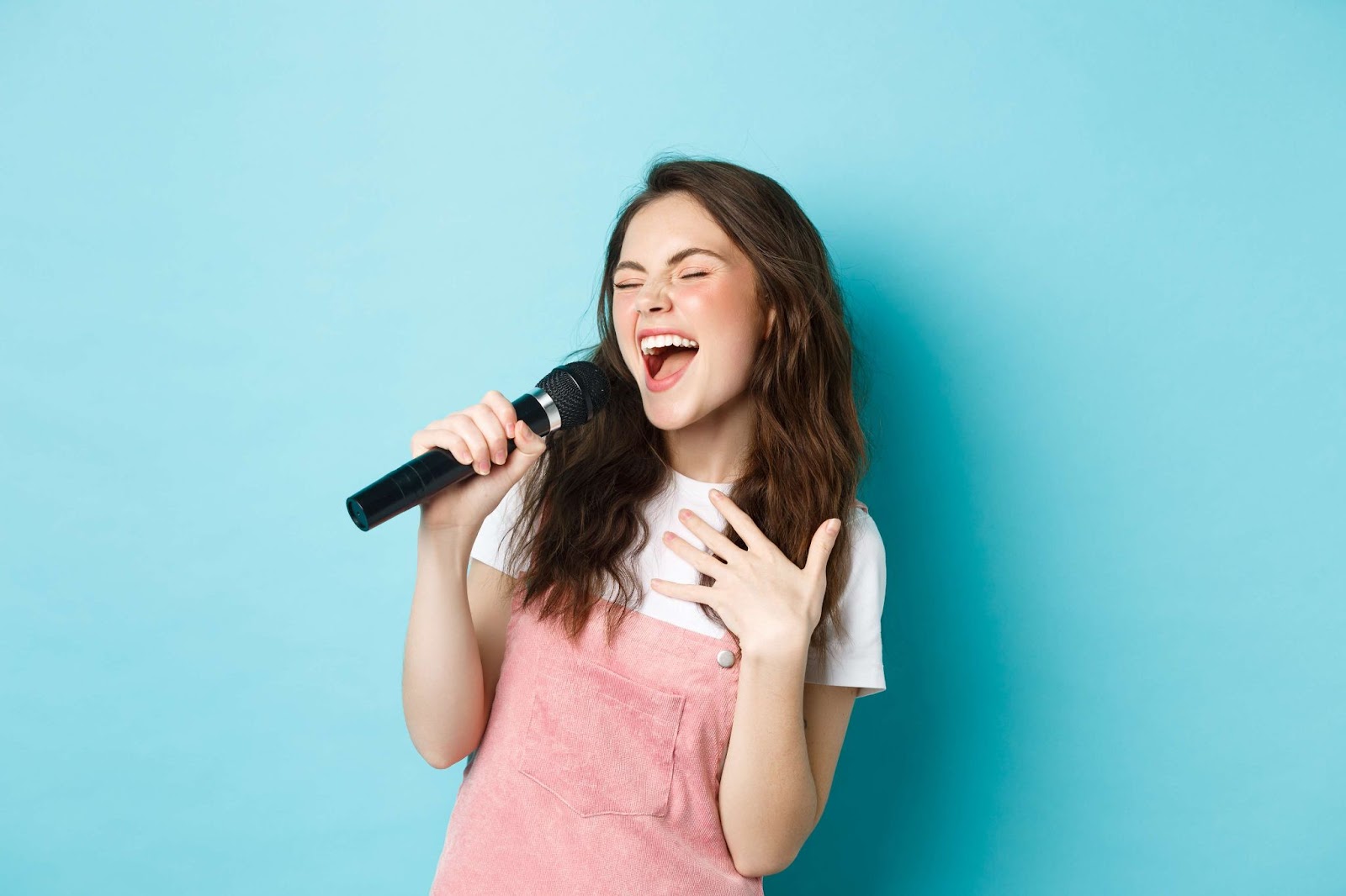 A girl singing against a blue background