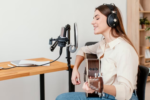 Woman recording a song playing the guitar