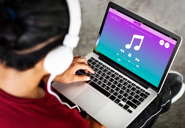 Man in headphones listening to music on laptop