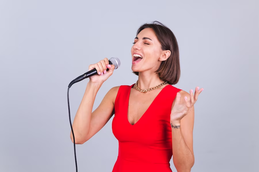 Woman in red singing into a microphone