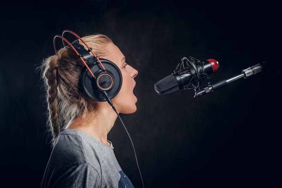 Woman singing with a headset and microphone in a studio