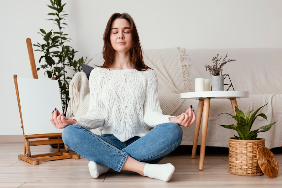 Meditating woman sitting cross-legged on the floor