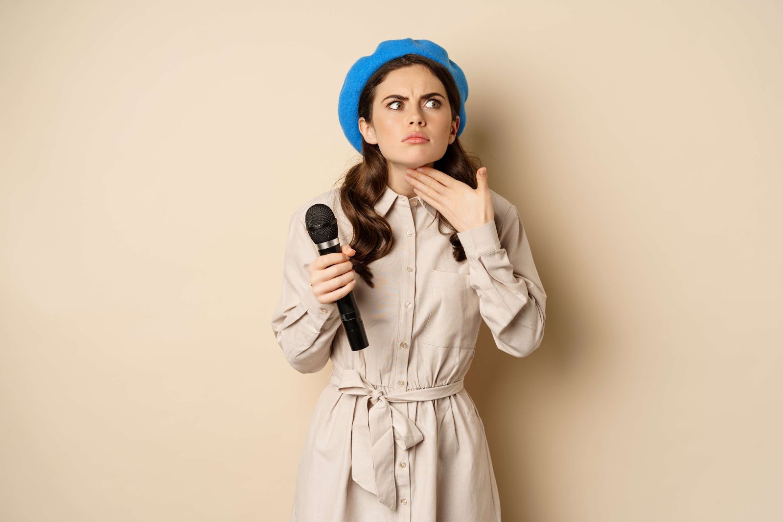 Woman with microphone touching throat